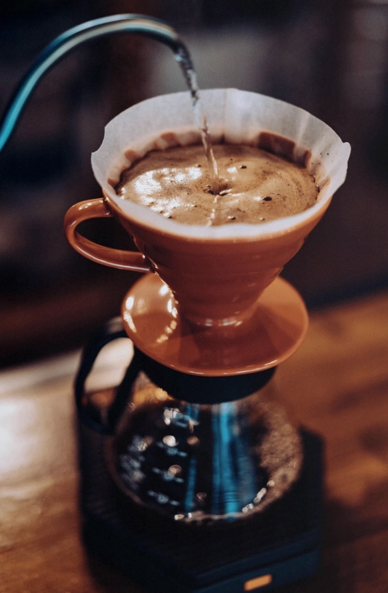 Cappuccino neben Hochzeitstorte auf dem Desserttisch